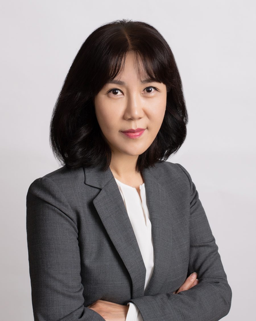 Ellie Hwang in a grey blazer, arms folded